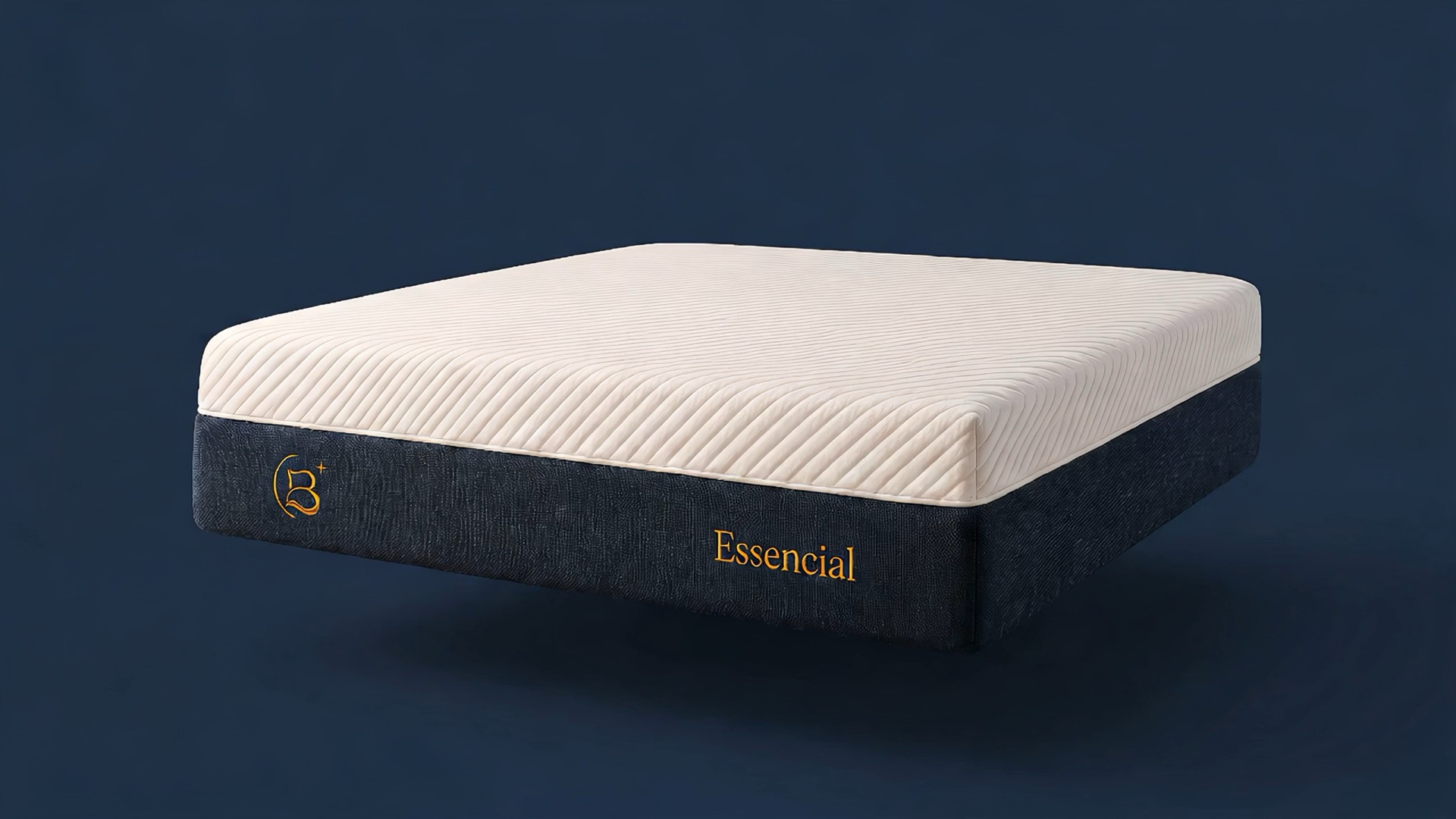 Colchão Brasoft Confort Essencial flutuando num vazio azul-escuro: tampo canelado branco e faixa lateral azul-marinho com bordados dourados